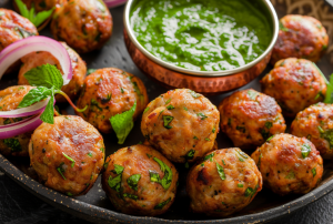 A bowl of mutton keema balls served with mint chutney