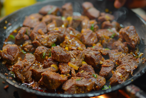 A finished plate of Madurai Mutton Chukka garnished with coriander leaves.