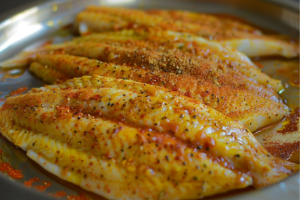 A plate of marinated fresh tilapia fillets for making fish burger