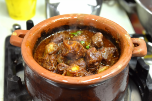 Tender lamb pieces simmering in rich, aromatic gravy inside a traditional clay pot for Hyderabadi Laziz Lamb Handi